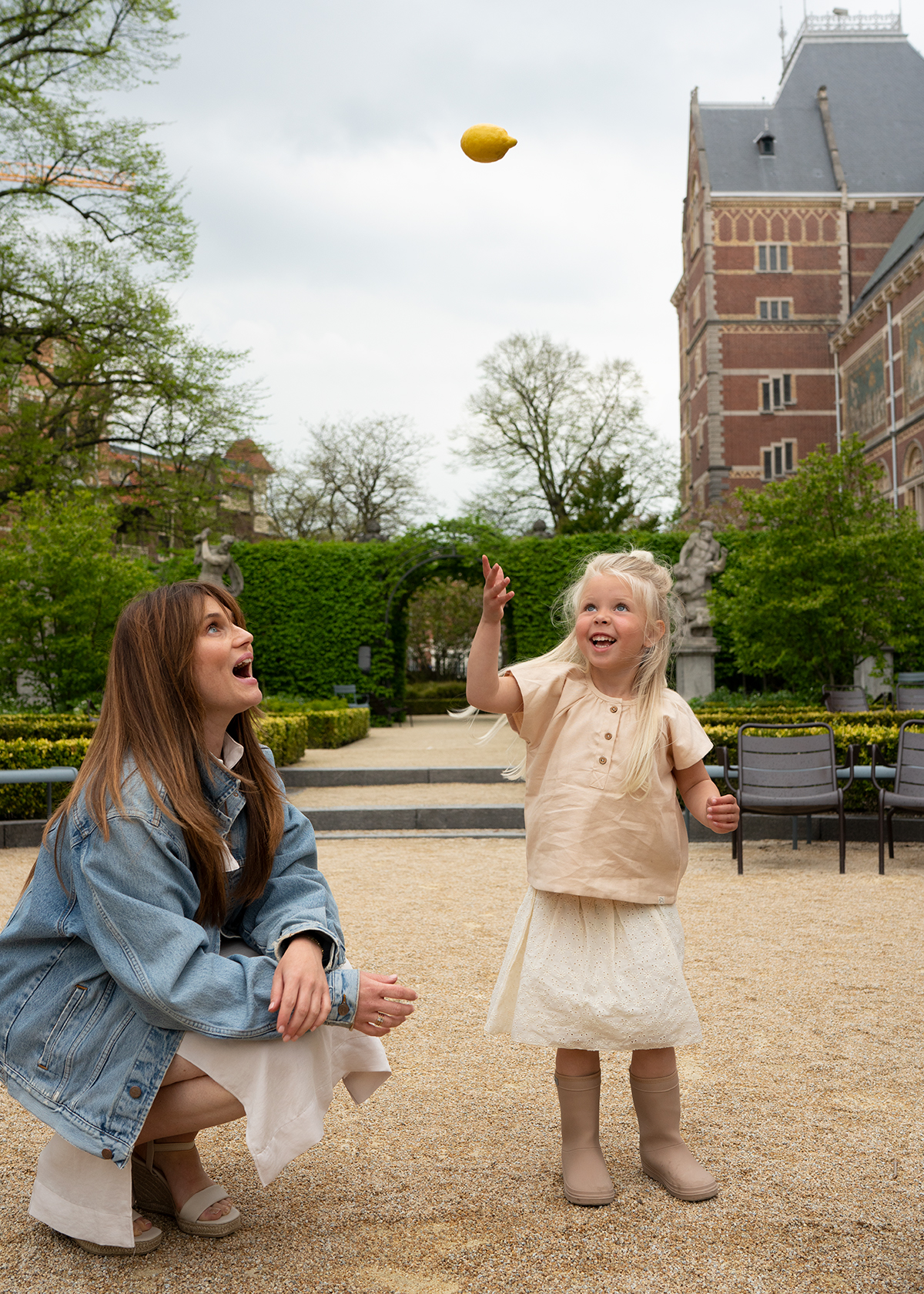 Rachelle met een kind in een tuin — symbolisch voor speelse groei en verbinding